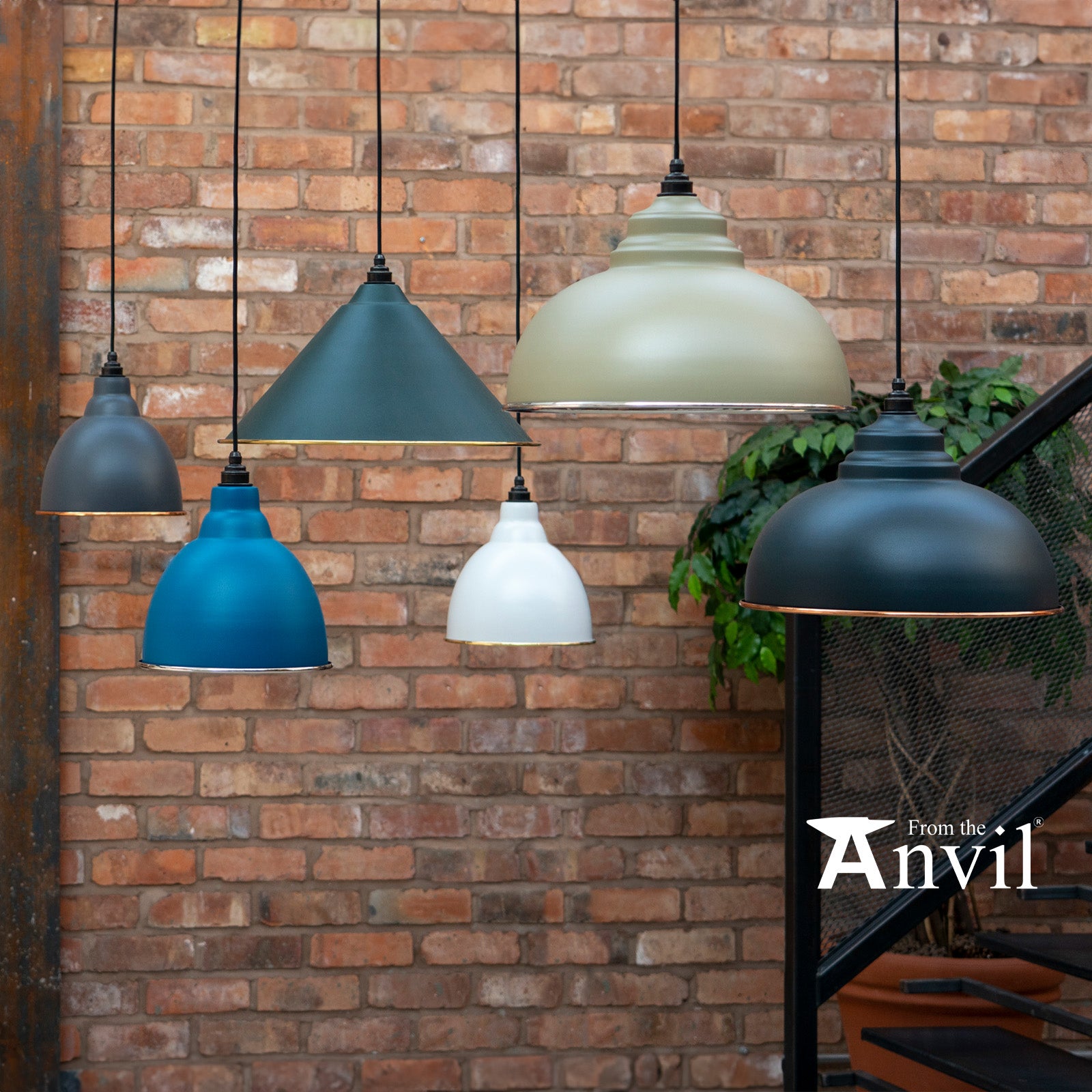 Image of several From The Anvil Lights hanging in front of a brick wall