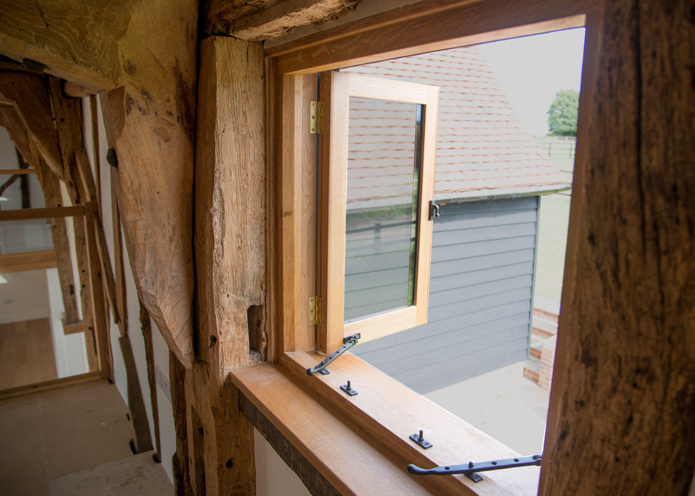 Open casement window with black cast iron window hardware