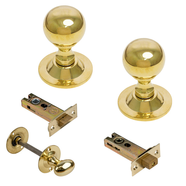  Two polished brass ball door knobs with matching strike plates and a brass keyhole thumb turn, shown on a clean white background.