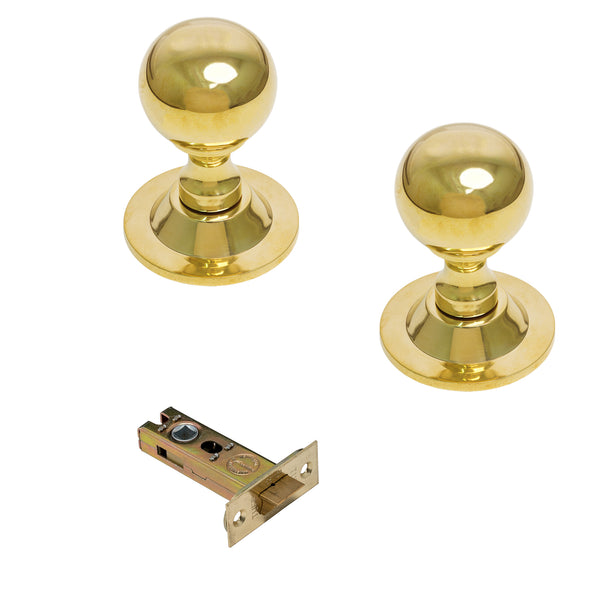  Two polished brass ball door knobs with matching metal strike plates on a white background.