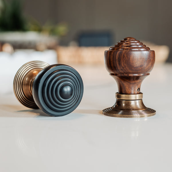  Two wooden door knobs on a white surface with a blurred background