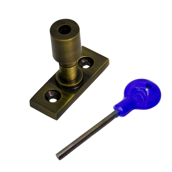  A brass sash  stopper with a matching flat mounting plate, shown alongside a blue-handled hex key on a plain white background.