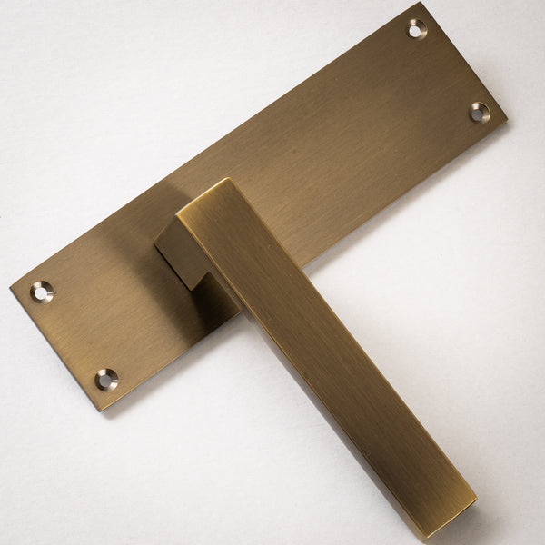 Metro Door Handles On Plate Latch Handle in Aged Brass 